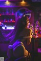 A woman sitting at a bar with a glass of wine.