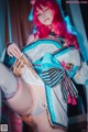 A woman with pink hair wearing a blue and white outfit.