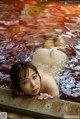 A naked woman laying in a pool of water.