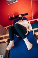 A woman wearing a face mask sitting on a blue bench.