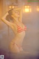 A woman in a bikini standing in a hot tub.